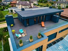 an aerial view of a house with blue sidings and patio furniture on the roof