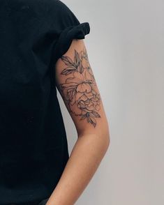 a woman's arm with a flower tattoo on the left side of her arm