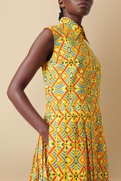 Product Description: Inspired by the historic mud cloth patterns dating back to the 12th century, this sleeveless cotton poplin dress features a reimagined and modernist geometric print. Each pattern holds a unique meaning, with this design symbolizing wealth and prosperity. The dress showcases a shirt-style bodice and a flowy pleated skirt, ensuring graceful movement. With a flattering and minimal silhouette, it has a belt and pockets for convenience. Dyed Indonesian mother-of-pearl buttons acc Mudcloth Pattern, Geo Print Dress, Unique Meaning, African Mudcloth, Cotton Poplin Dress, Sleeveless Shirt Dress, Wealth And Prosperity, Batik Fashion, African Mud Cloth