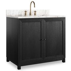 a bathroom vanity with marble counter top and black wood cabinet doors, two brass faucets on the side