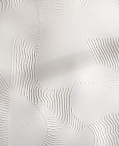 the textured paper is white and has wavy lines on it, as well as an abstract pattern