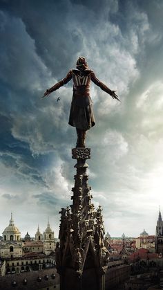 a statue is standing on top of a building with clouds in the sky behind it