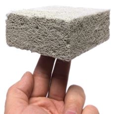 a hand holding up a piece of cement