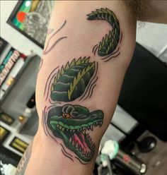 a man's arm with two green snakes on it