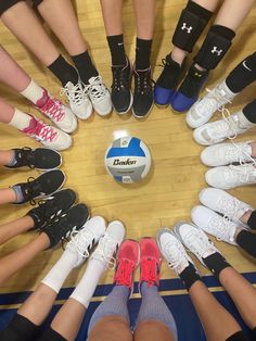 a group of people standing in a circle on top of a wooden floor with shoes