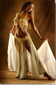 a beautiful woman in a belly dance outfit posing for a photo with her white shawl