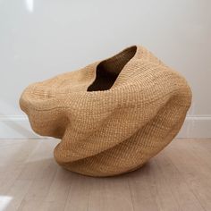 a large brown chair sitting on top of a hard wood floor next to a white wall