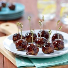 small appetizers with toothpicks are on a white plate and ready to be eaten