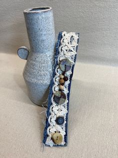 two blue vases sitting next to each other on top of a white cloth covered table