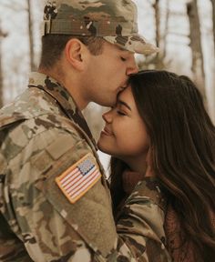 a soldier kissing his girlfriend in the woods