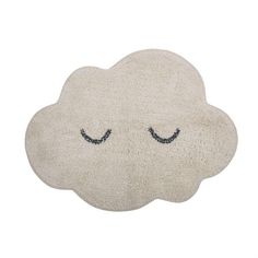 a cloud shaped rug with eyes drawn on it