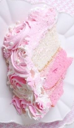 a piece of cake with pink frosting and white icing on a paper plate