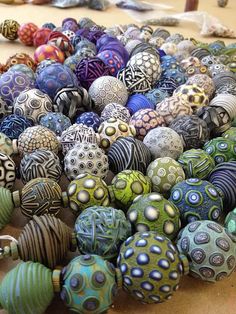 there are many different colored balls on the table together and one has a silver bead in it