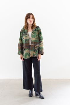 "Camouflage cotton shirt with five button closure, two lower front flap pockets, side pleats. Tabs at cuff. Wear as a shirt or lightweight outer layer. These were originally made for women so the shape accentuates the waist. Maker: Military |  Made in USA  |  Material: 100% Cotton ripstop lightweight  Condition: Good with small bits of wear including small holes, small darns, small patch shadows. Not perfect but overall very wearable and good.  X-SMALL: Shoulders: 16\"  |  Chest: 18-19\"  |  Len Casual Camouflage Utility Jacket With Flap Pockets, Casual Camouflage Utility Jacket With Pockets, Camouflage Cotton Utility Jacket For Outdoor, Camouflage Cotton Outerwear With Pockets, Cotton Camouflage Outerwear With Pockets, Camouflage Cotton Utility Jacket For Streetwear, Camouflage Cotton Outerwear With Flap Pockets, Military Style Khaki Utility Jacket With Button Cuffs, Military Style Cotton Utility Jacket With Button Cuffs