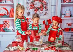 three children in red and green aprons making christmas cookies on a table with holiday decorations