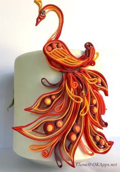 an orange and red peacock sculpture on a white surface