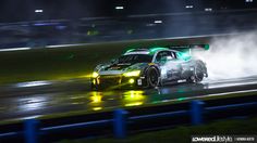 a car driving on a wet track at night