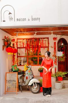 a woman standing in front of a store with red decorations on the walls and windows