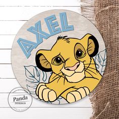 the lion cub is sitting on top of a wooden sign that says, avael