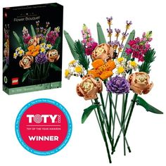 a bouquet of flowers sitting on top of a table next to a box with the title toy of the year award