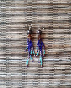 These long fringe beaded dangle earrings are certain to bring you admiring gazes!  Each earring has five strands of woodsy brown, cobalt blue, variegated iridescent  purple, sky blue, and copper color glass seed beads flowing from a round wooden bead.  These long, colorful, boldly addictive beaded earrings are unique, very lightweight and comfortable.  The strands are made with durable nylon beading thread and glass seed beads. The length of these earrings is 3.75 inches (from the top of the ear wire to the bottom of the beaded strands).  They have stainless steel hook style ear wires.  I love to use these particular ear wires because they hold the earring up, very close to your ear so there is no "wasted space".   beaded bracelets: https://www.etsy.com/shop/RanchoArt?section_id=26148298 T Southwestern Fringe Dangle Earrings, Southwestern Fringe Earrings With Round Beads, Southwestern Beaded Fringe Dangle Earrings, Southwestern Style Beaded Fringe Dangle Earrings, Bohemian Chandelier Earrings With Fringe And Round Beads, Bohemian Chandelier Earrings With Fringe, Bohemian Long Drop Fringe Earrings, Bohemian Long Drop Tassel Earrings, Bohemian Long Drop Chandelier Earrings With Tassels