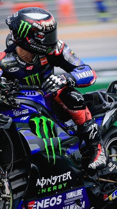 a man riding on the back of a blue motorcycle