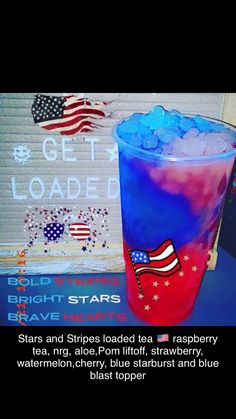 a red white and blue drink sitting on top of a table next to a sign