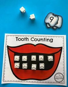 a tooth and some dices sitting on top of a blue surface with the word, tooth counting