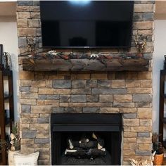 a stone fireplace with a flat screen tv above it