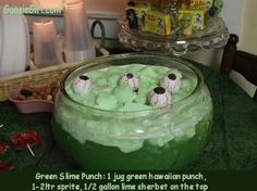 green slime punch in a glass bowl with googly eyes on the top and gummy balls inside