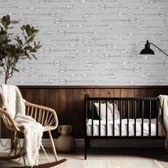 a baby's room with a crib, rocking chair and potted plant