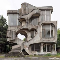 an unusual looking building with stairs leading up to the second floor and windows on each side