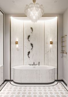 a bathroom with a large white bathtub next to a chandelier hanging from the ceiling