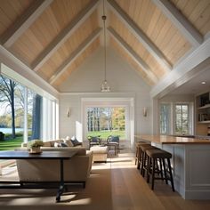 a living room filled with furniture next to a kitchen and an open concept dining area