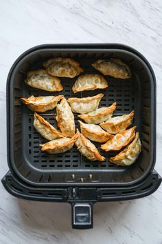 fried dumplings in an air fryer on a marble surface