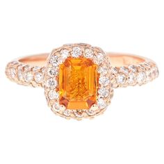 This beautiful ring has Natural Emerald Cut Orange Sapphire that weighs 1.03 Carats and is surrounded 64 Round Cut Diamonds that weigh 0.89 Carats. The total carat weight of the ring is 1.92 Carats. The ring is beautifully set in a classic 14 Karat Rose Gold setting, with an approximate weight of 3.7 grams. It is a size 7 and can be re-sized, free of charge, if needed. Orange Wedding Rings, Orange Wedding Ring, Orange Engagement Ring, Orange Gemstones, Orange Sapphire Ring, Pink Sapphire Diamond Ring, Citrine Birthstone, Orange Ring, Cut Orange