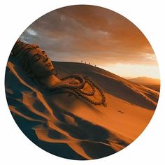 a woman's head in the sand at sunset