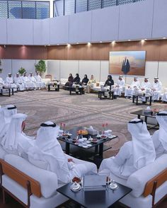 a group of men sitting in chairs around a table