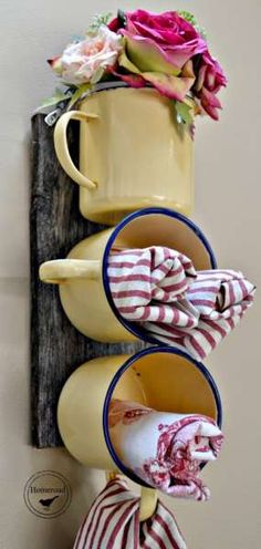 three cups are stacked on top of each other and tied to a wall with ribbons