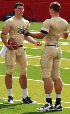 two football players shake hands on the field