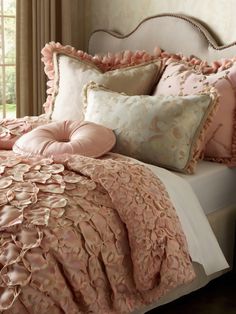 a bed with pink comforters and pillows on it