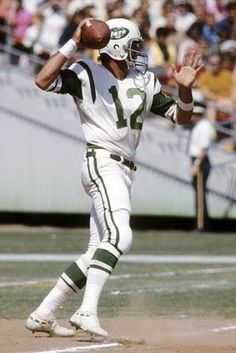 a football player throwing a ball on top of a field in front of a crowd