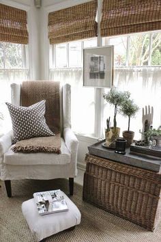 a living room with wicker furniture and large windows in the window sill area