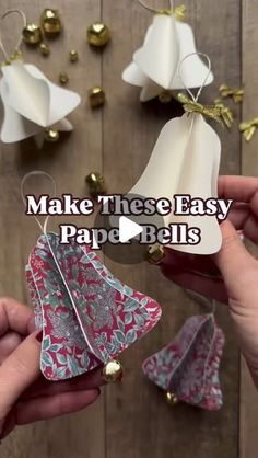 two hands are holding paper bells with the words make these easy paper bells