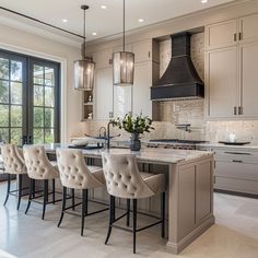 a large kitchen with an island and chairs