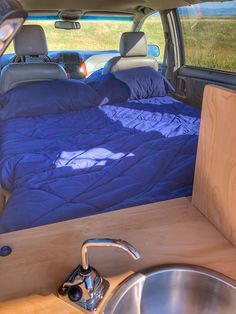 the interior of a van with a bed and sink