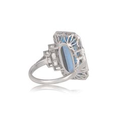 an art deco style ring with blue stones and diamonds on the sides, set in white gold