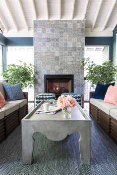 a living room filled with furniture and a fire place in the middle of a room