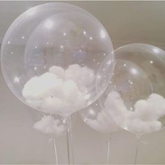 three clear balloons with white clouds on them