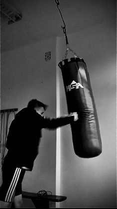 black and white photograph of a man hitting a punching bag